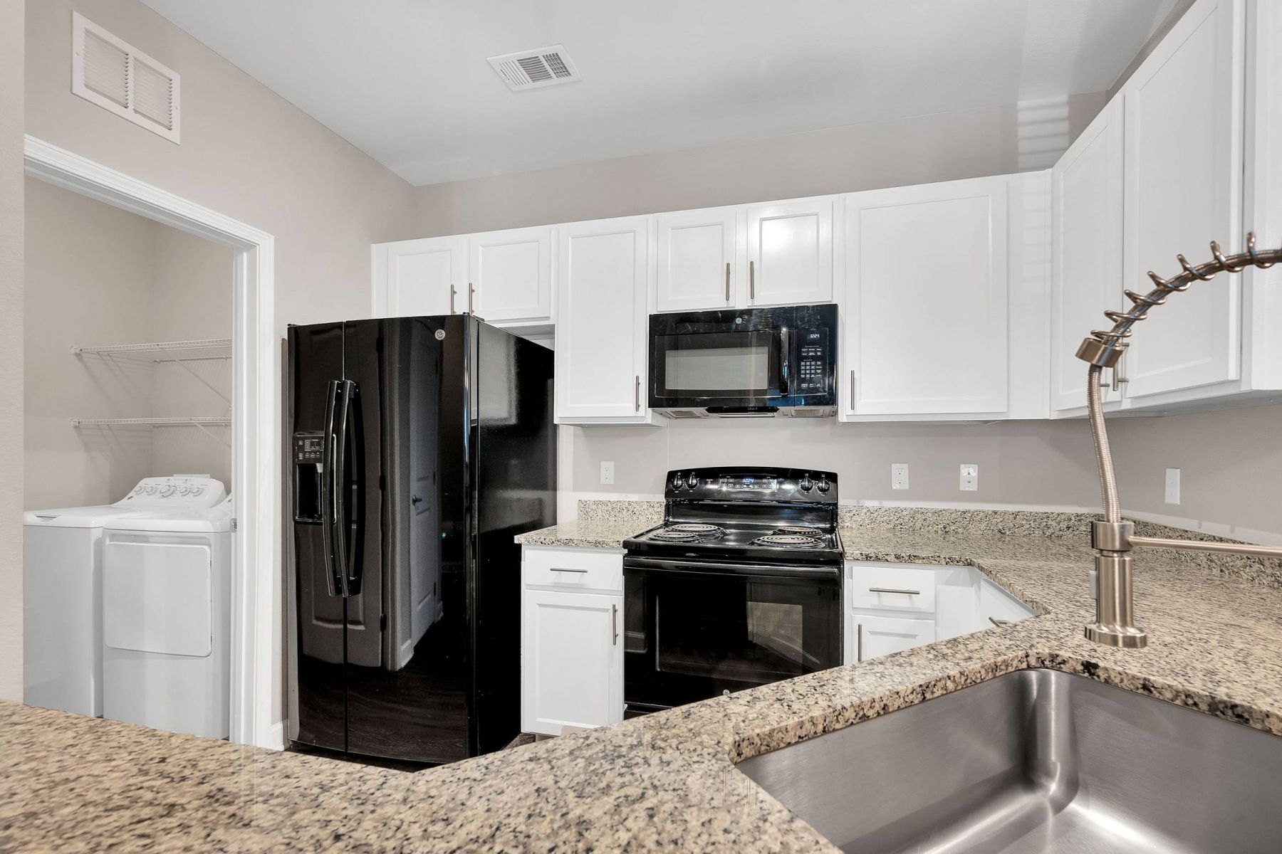 Luxury apartment kitchen with stainless steel appliances, granite countertops, and lots of storage space